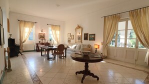 A spacious living room with a dining area, a sofa, a coffee table, and a fireplace. - Relais Delle Rose - Mimmi Executive Suite (Lecce)