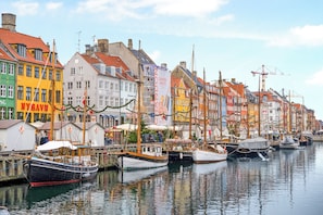Uma orla com edifícios coloridos e barcos atracados na costa.