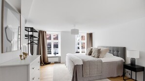 A modern bedroom with a bed, bedside table, and a dresser.