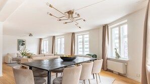 A modern living room with a dining table, sofas, and a large window with curtains. - Regent 7 - Large 3 Bdr Apt With Balcony in City Centre (Copenhagen)