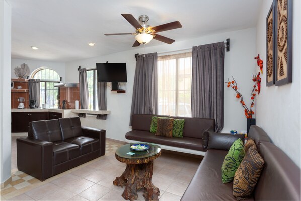 A modern living room with a sofa, a coffee table, and a ceiling fan.