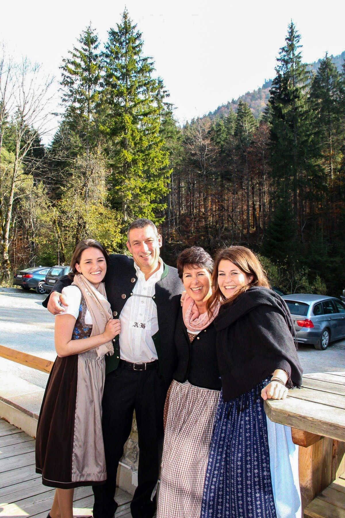 A group of people posing in an outdoor setting with a forested background.