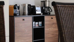 Eine Küchenzeile mit Kaffeemaschine, Toaster und Wasserkocher auf einem Holzkorpus.