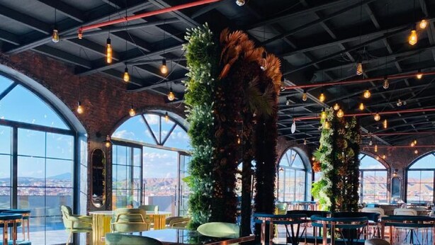 Un espacio interior amplio con techos altos, ventanas grandes y una distribución de asientos moderna.