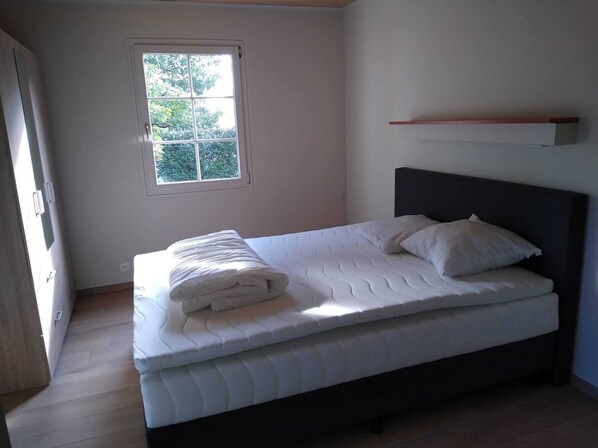 Une chambre à coucher avec un lit, une fenêtre et une étagère.