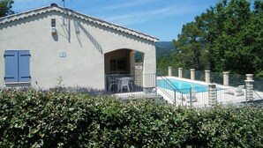 A building with a pool, a covered patio, and a view of the surrounding landscape. - Le Sapin B : Mooie Vakantiewoning met Zwembad in de Ardèche (Chassagnes)