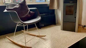 Una cocina moderna con una mecedora, horno empotrado y ventana con vista a la calle.