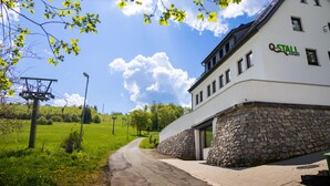 En vit byggnad med en grund av sten och en skylt med texten ”Q-STALL Apartments”.