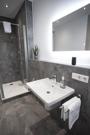 Een douche, een haardroger, handdoeken, toiletpapier