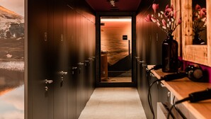 Un pasillo con un cartel de spa, puertas de madera y un espejo con flores.