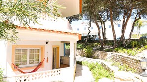 A house with a hammock, a stone wall, and a view of the street. - The Quiet Loft Golf & Beach resort (Amoreira)