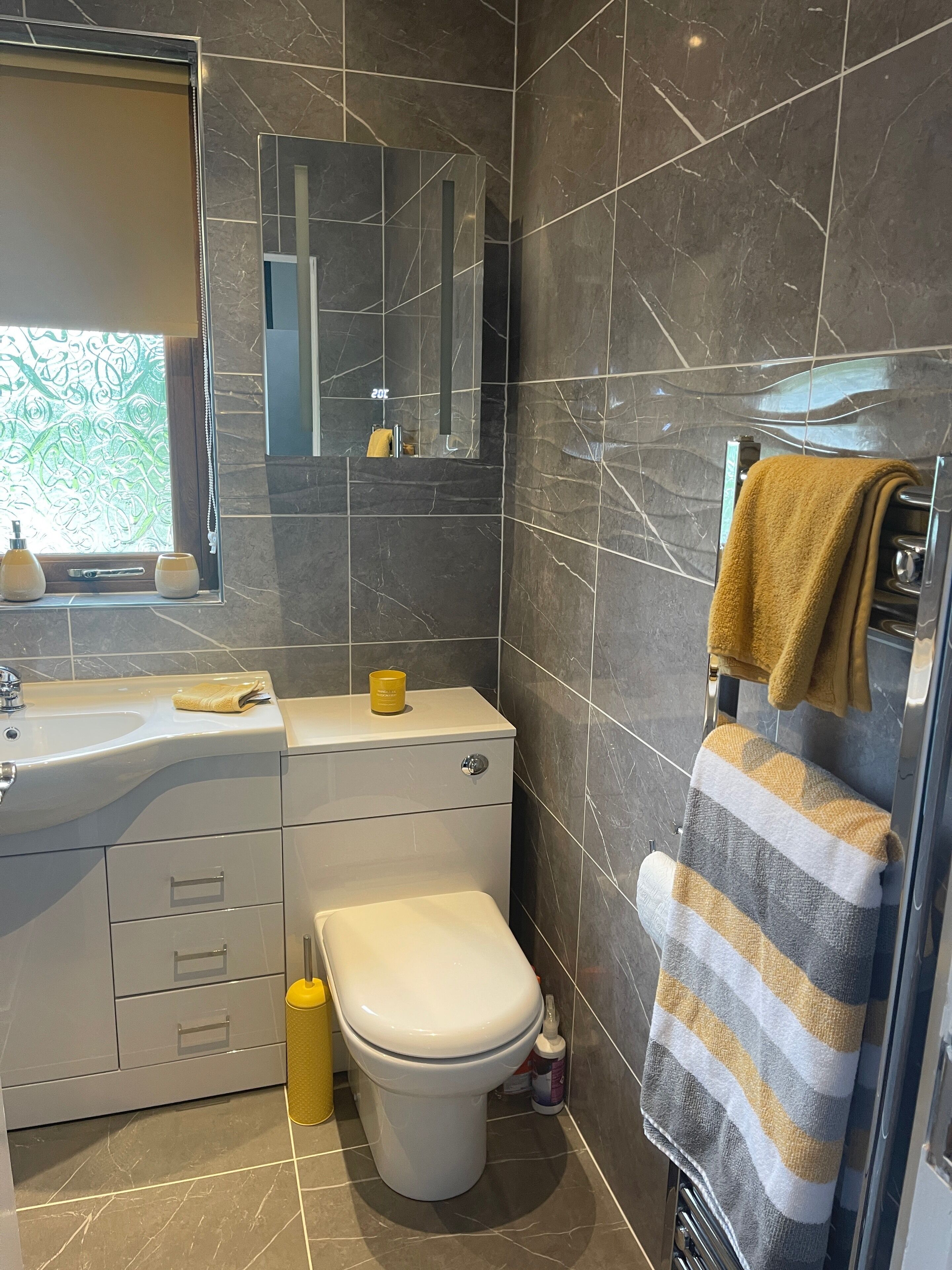 Une salle de bain moderne avec des toilettes, un lavabo et un miroir.