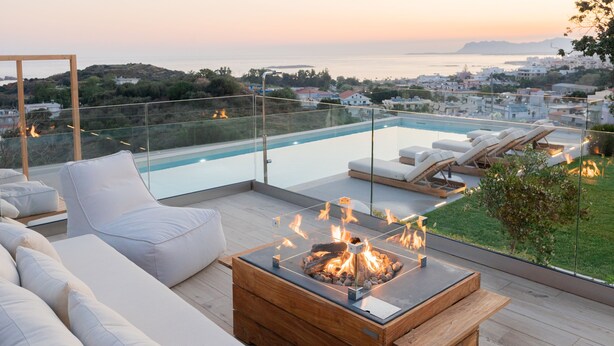 Une terrasse sur le toit avec une piscine, des chaises longues et un foyer à bois.