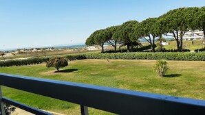 A grassy area with trees and a view of the sea. - Studio for 2 Adults, Sea & Garden View (Le Grau-du-Roi)