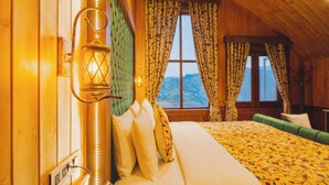 Una habitación acogedora con una cama, una lámpara y un ventanal con cortinas.
