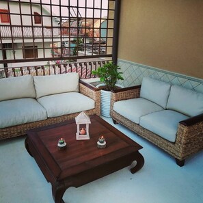 A balcony with wicker sofas, a wooden coffee table, and a potted plant. - Bruno's Home - A casa di Bruno (Sicilia)