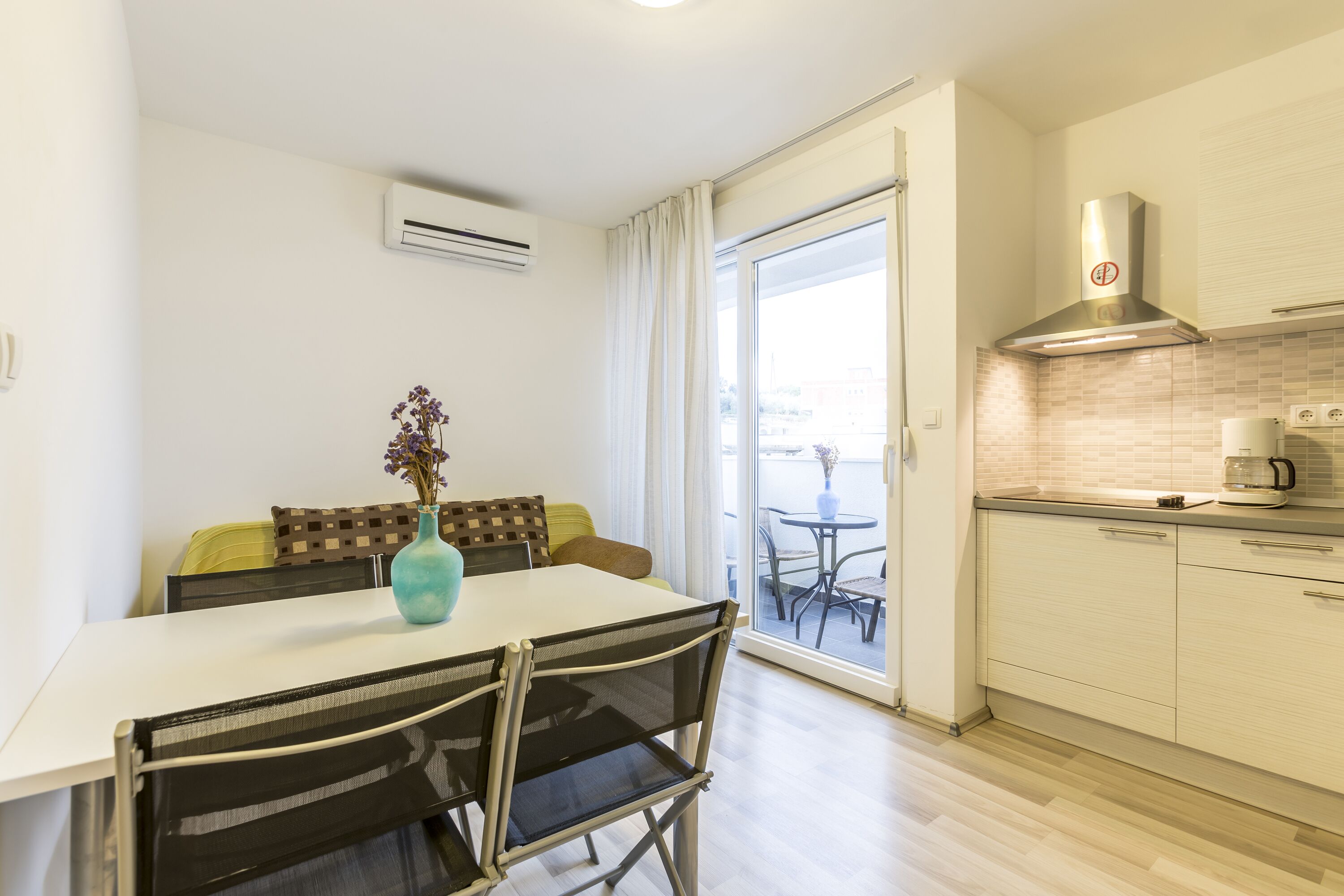 A compact kitchen with a dining area, a large window, and a view of the outside.