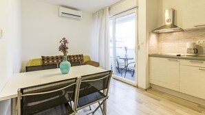 A compact kitchen with a dining area, a large window, and a view of the outside. - A1 - Spacious apt With the sea View & use of Pool (Podstrana)