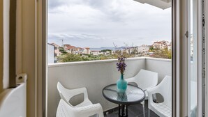 A balcony with two white wicker chairs, a small round table, and a vase with flowers. - A2 - Spacious apt With the sea View & use of Pool (Podstrana)