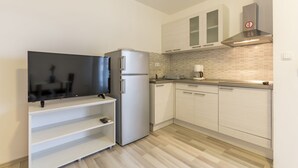 A modern kitchen with a built-in TV, stainless steel refrigerator, and white cabinetry. - A2 - Spacious apt With the sea View & use of Pool (Podstrana)