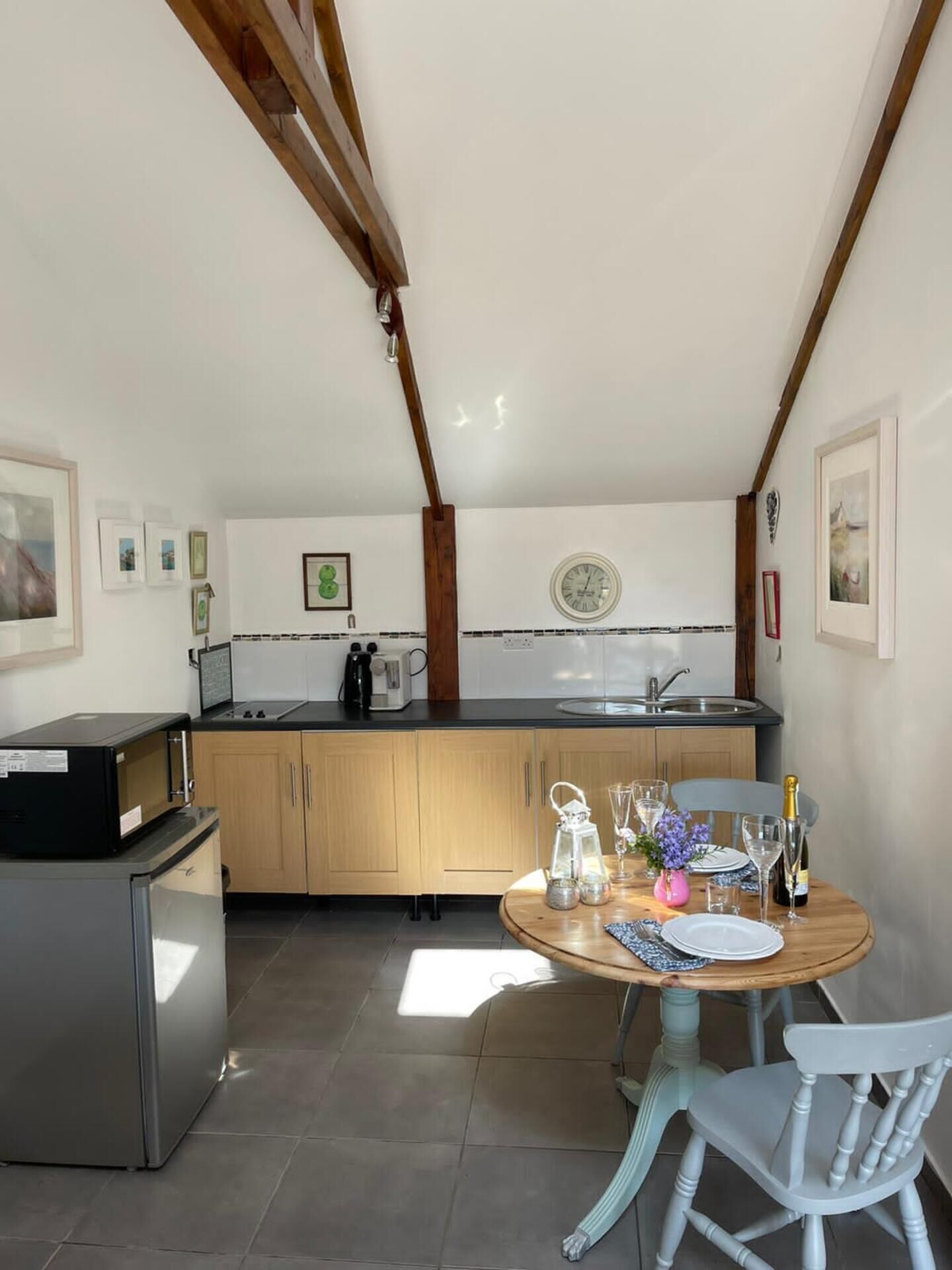 A modern kitchen with wooden cabinets, a built-in oven, and a dining area with a wooden table and chairs.
