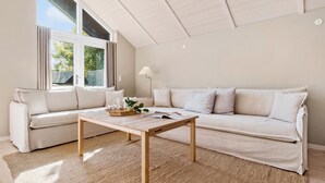 Un salon moderne avec un canapé, une table basse et une lampe.