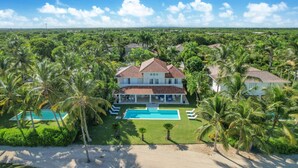 Una grande casa con piscina, circondata da palme.
