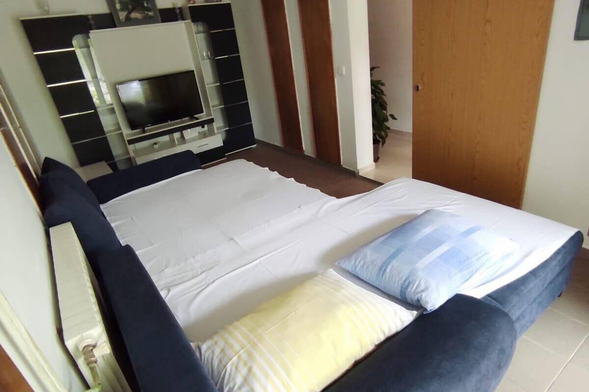 Une chambre à coucher avec un lit, une télévision et une armoire.