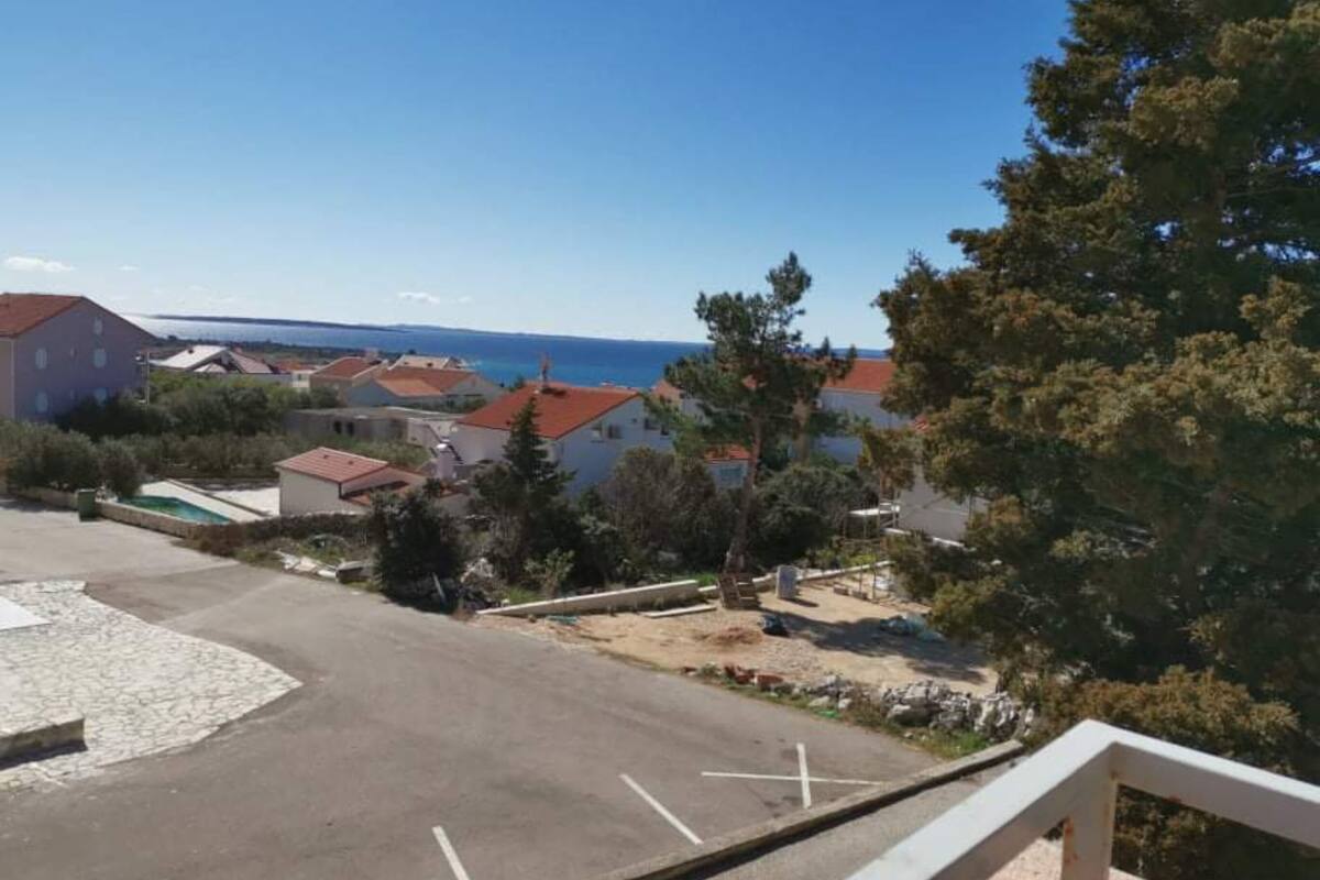 Un quartier résidentiel avec des maisons, un ciel dégagé et une vue sur la mer.