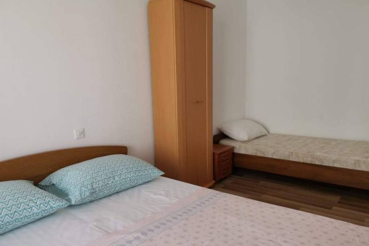 Une chambre à coucher avec un lit, une armoire et une table de chevet.