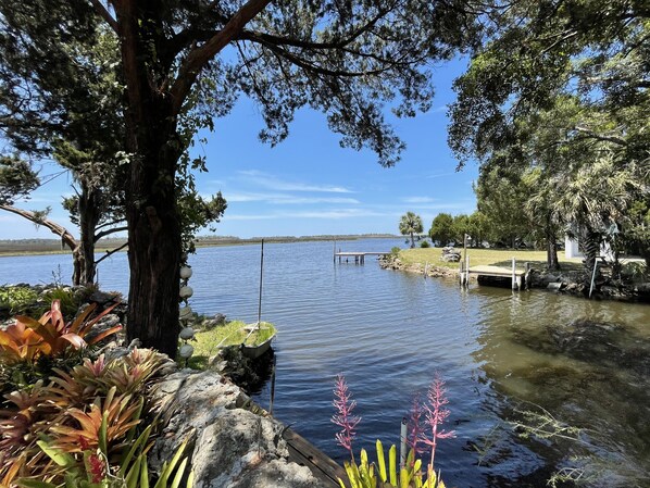 A calm lake with a dock extending into the water, surrounded by trees and rocks.