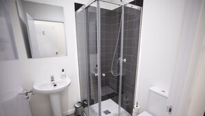 A modern bathroom with a glass-enclosed shower, a pedestal sink, and a toilet. - Hostel MYD La Latina (Madrid)
