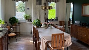 Un comedor con una mesa larga, sillas de madera y un candelabro.