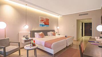 A modern hotel room with a large bed, bedside tables, a desk, and a chair.