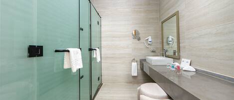 A modern bathroom with a glass shower enclosure, a vanity with a mirror, and a towel rack.