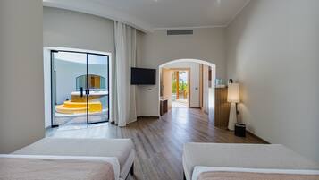 A hotel room with two beds, a TV, a lamp, and a view of a spiral staircase.
