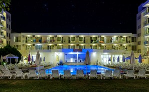 A hotel with a swimming pool, multiple balconies, and a sign for Suneco Club Garden Nevis. - Garden Nevis - All Inclusive (Sunny Beach)