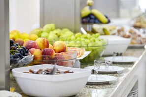 A buffet with various fruits and a glass bowl of fruit salad. - Garden Nevis - All Inclusive (Sunny Beach)