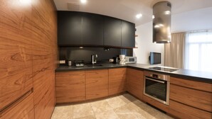 Una cocina moderna con armarios de madera, horno integrado y microondas.