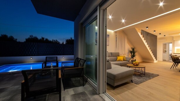 A modern living room with a pool, a staircase, and a dining area. - Luxury Villa Luna Kastela (Kaštel Stari)