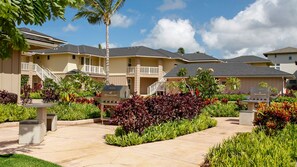 Un hôtel doté de nombreux balcons, de barbecues extérieurs et d’un jardin bien entretenu où l’on trouve différentes espèces de plantes.
