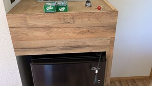 Una cocina compacta con un lavamanos integrado, un refrigerador pequeño y una encimera de madera.