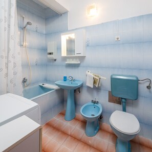 Un bagno con vasca, lavandino, bidet e water.