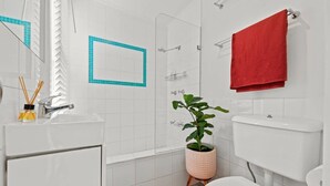 A bathroom with a white sink, a red towel, a shower, and a potted plant. - Perfect Laneway Terrace, Surry Hills (Surry Hills)