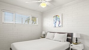 A bedroom with a bed, two bedside tables, a ceiling fan, and a window with blinds. - Pinchot Tres | Old Town Scottsdale (Scottsdale)