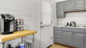 Una cocina con cafetera, especiero y lavabo.
