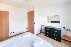 Un dormitorio con cama, cómoda, silla y espejo.