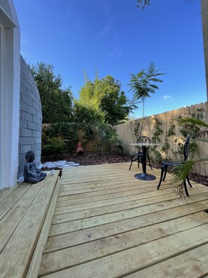 A wooden deck with a Buddha statue, a table, and chairs. - ❌not a tent❌ Unique DOME 💜Blue Moon 💜 (Largo)