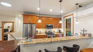 A modern kitchen with wooden cabinets, stainless steel appliances, and a granite countertop. - Swan View Refuge-Luxury 2 bedroom sleeps 4 (Somers)
