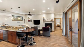A modern kitchen with a central island, bar stools, a fireplace, and a TV mounted on the wall. - Swan View Refuge-Luxury 2 bedroom sleeps 4 (Somers)